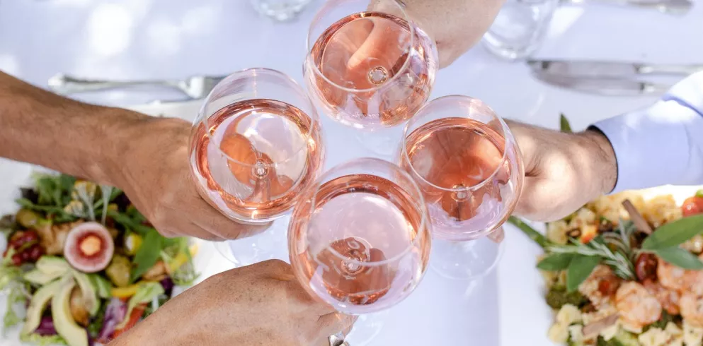 Weingläser mit Roséwein und Tellern mit Gerichten