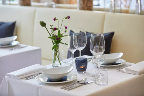 Wiedemanns Weinhotel Restaurantansicht mit gedecktem Tisch und Weingläsern